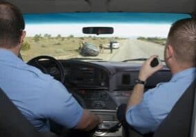 Paramedics arriving at car crash scene, view from ambulance